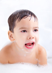 displeased boy taking a bath