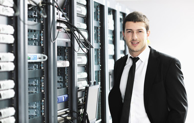 businessman with laptop in network server room