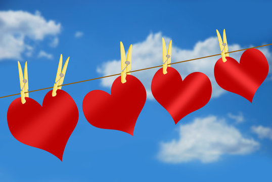 red hearts on clothesline against blue sky