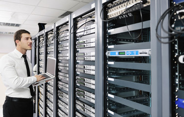 businessman with laptop in network server room