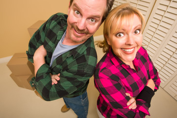 Proud Goofy Couple and Moving Boxes in Empty Room