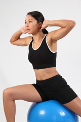 Fitness routine using exercise ball by young woman