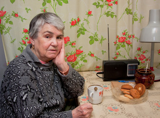 an elderly grey woman   drinks tea