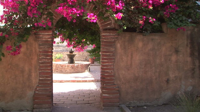 Fountain seen through an arch in Mission San Juan Capistrano