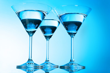 Three martini glasses on blue background