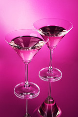 Two martini glasses on red background