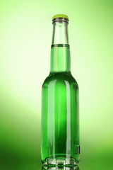 Bottle with alcohol on green background