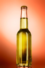 Bottle with alcohol on orange background