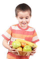 Little boy holding apples tangerines and banana