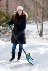 Smiling woman shoveling snow