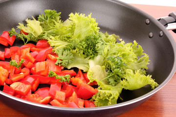 frying pan with vegetables  on the table