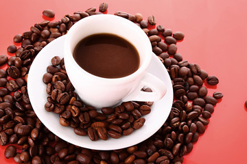 Small white cup of coffee with coffee grain  on red background