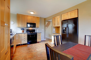 Maple cabinets in brown large kitchen