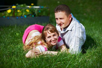 Happy young woman and man on green grass