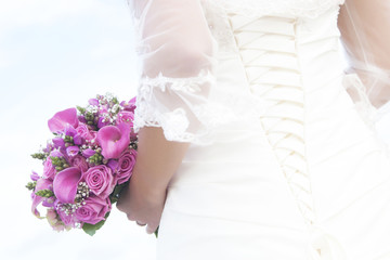 bride holding bouguet with purple and pink flowers