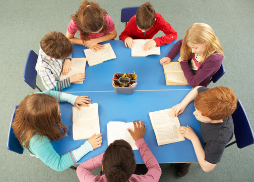 Overhead View Of Schoolchildren Working Together At Desk