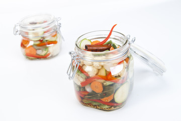 deux bocaux de conserve avec légumes sur fond blanc