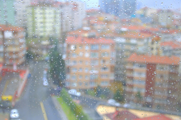 Drops of rain on a window pane, buildings in background
