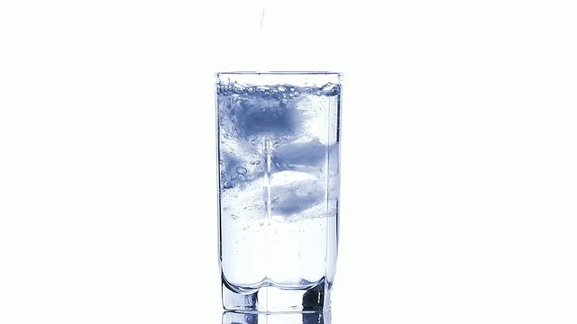 Water pouring into a glass with ice cubes isolated on white, HD
