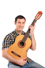 A young man playing acoustic guitar