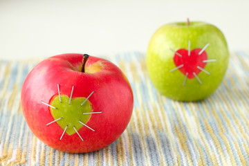 green and red apple with a heart symbol
