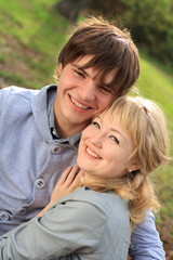 Fototapeta premium Young cheerful smiling couple in the park