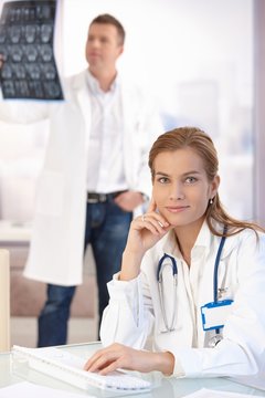 Attractive female doctor working on computer