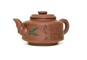 Глиняный чайник крупным планом на белом фоне.