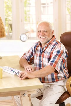 Portrait of elderly man in study at home