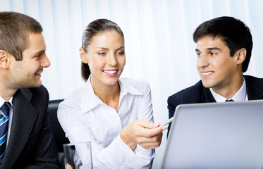 Obraz premium Three businesspeople working with laptop at office
