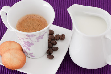 an elegant cup of coffee with milk and  biscuits