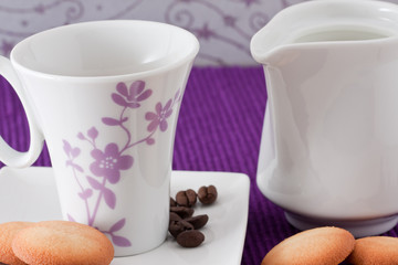 an elegant cup of coffee with milk and  biscuits