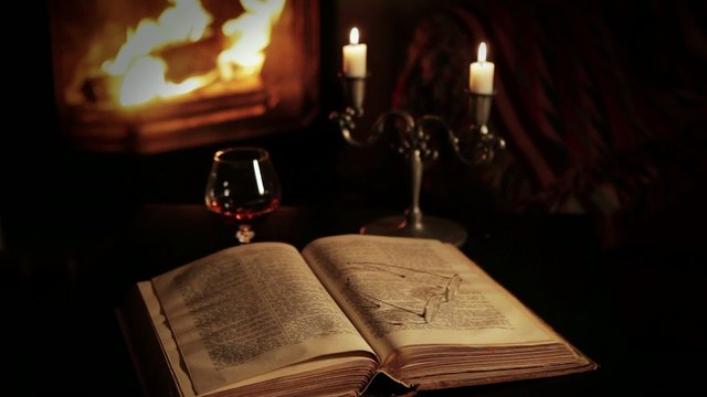 Reading in front of the fireplace with a glass of brandy.
