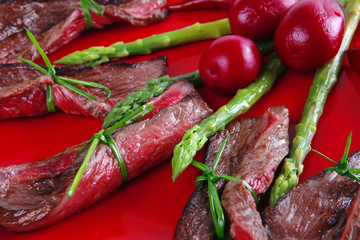 meat slices and asparagus on red
