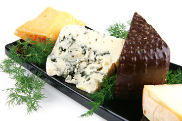 aged cheeses on black plate