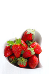 Fresh strawberries in cup shape of  heart isolated on white back