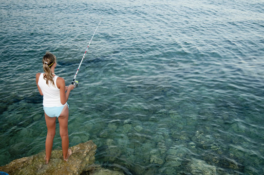 Young girl fishing at the beach