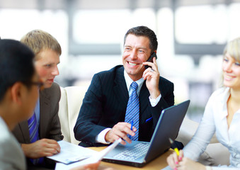 business man speaking on the phone while in a meeting
