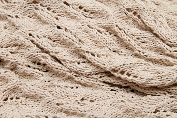 a beige knitted fabric. a close up.