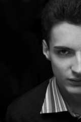 Young attractive macho on black background