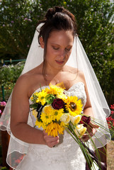 jeune mariée regardant son bouquet de fleurs