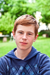 portrait of sad looking boy in the garden