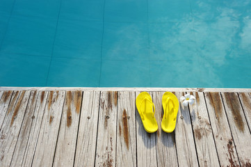 Fototapeta na wymiar Sandals by a swimming pool