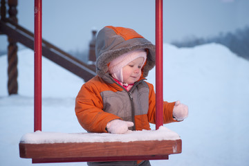 Cute baby stay and hold kids swing in winter evening