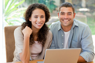 Lovers looking at their laptop at home