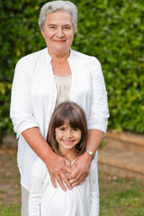 Grandmother with her granddaughter looking at the camera in the