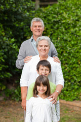 Fototapeta premium Grandparents with their children looking at the camera in the ga