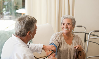 Doctor taking the blood pressure of his patient