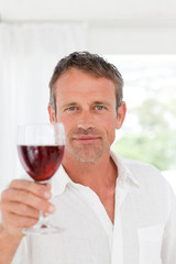 Man with his wineglass in his kitchen