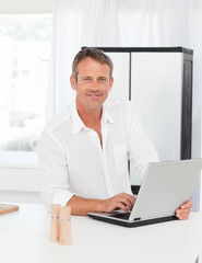 Man working on his laptop in his kitchen